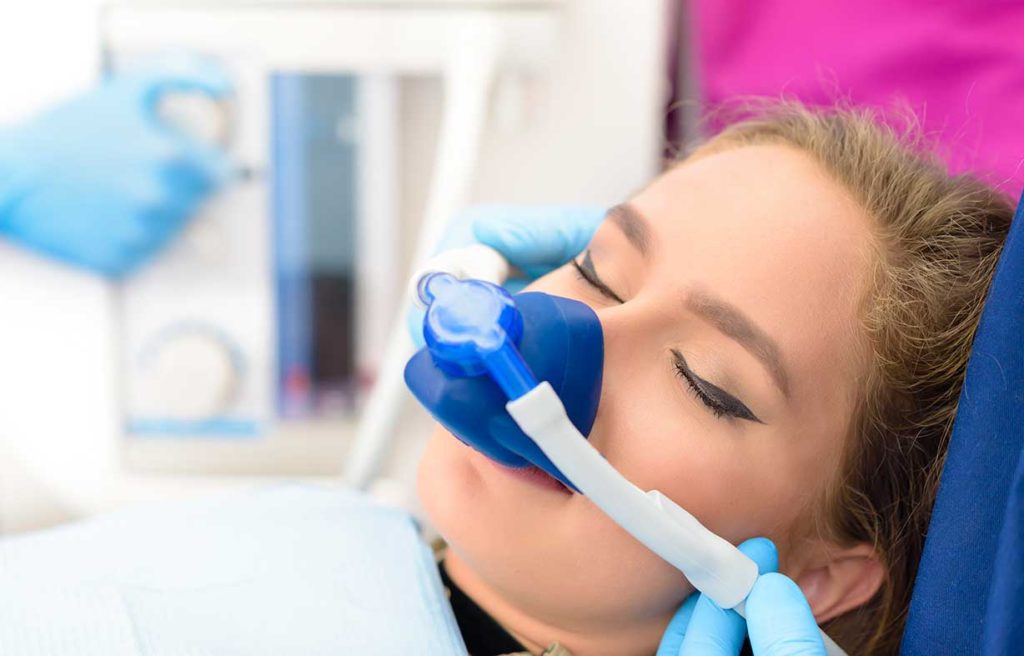Woman receiving nitrous oxide. Ivy Lane Dentistry offers minimal sedation options for dentistry procedures. Serving San Antonio, TX. 