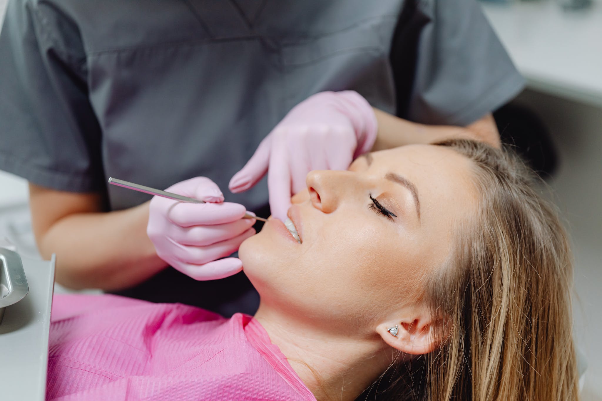 Image of a woman getting her teeth clenaed while almost asleep. Ivy Lane Dentistry offers deep sedation options for its patients in San Antonio, TX. 